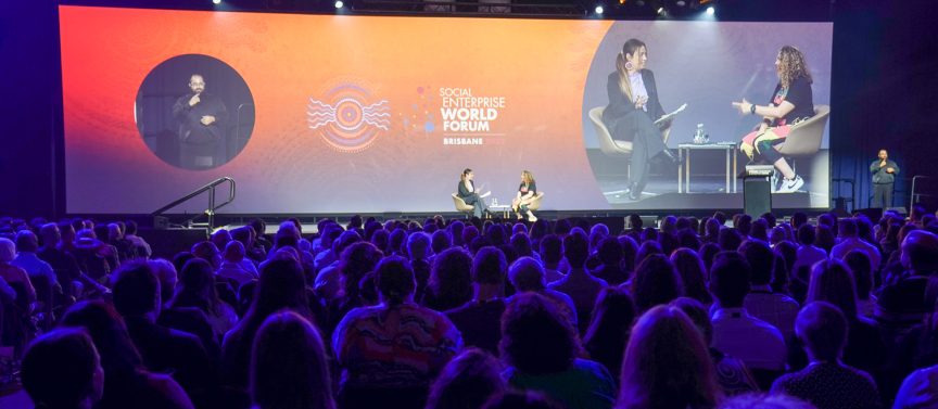A large crowd of people looking at a large stage with two SEWF22 speakers