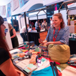 What is a social enterprise? An image of two women at a market stall, talking and smiling.